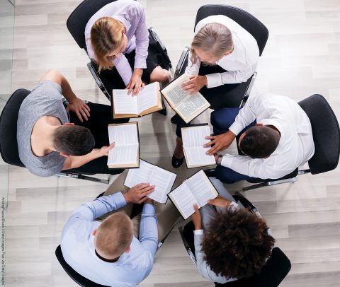 High Angle View Of People Sitting In A Circle Reading Bible