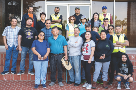 Los voluntarios, algunos de los cuales han estado ayudando durante todo el día, se reúnen para una foto después de que el banco de alimentos cierra y se completa el desmontaje.