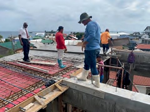Local workers laying support beams for the trusses for the new roof.