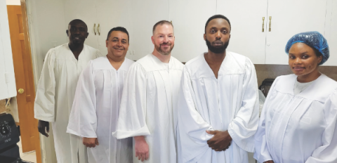 Byron, in the middle, along with four other candidates, gets ready to be baptized.