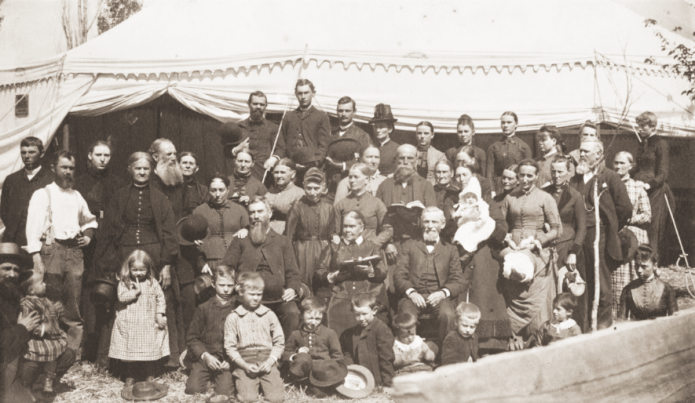 Ellen G. White, seated behind children with Bible open, and J.N. Loughborough, on her left, at Reno, Nevada, camp meeting, 1888.
