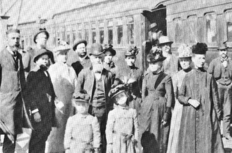The E.J. Waggoner family and other Adventist workers prepare to board a train in Oakland, headed for the East, either 1889 or 1890. Dr. Waggoner is standing in front, second from the left; his wife, Jessie, is the woman standing furthest to the right; J.N. Loughborough (with white beard and hat) stands behind the Waggoners’ daughters, Pearl and Bessie.