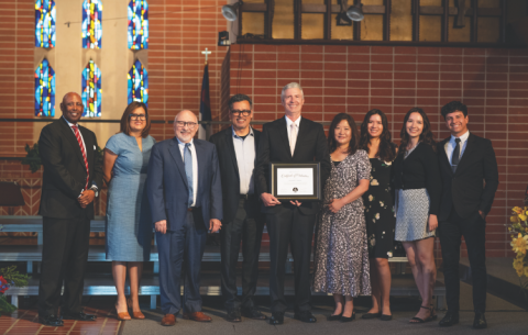 <p>Sewell holds his ordination certificate, surrounded by colleagues and his family</p><p>Sewell sostiene su certificado de ordenación, rodeado de colegas y de su familia.</p>