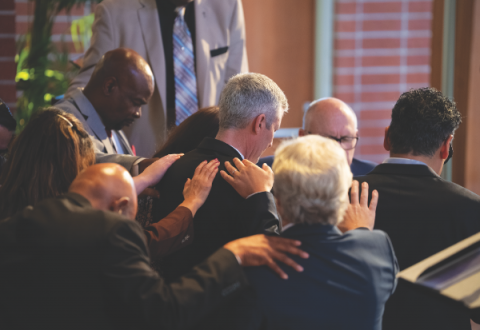 SCC Executive Secretary Danny Chan offers the ordination prayer as ordained ministers in attendance lay hands on Sewell and his wife.