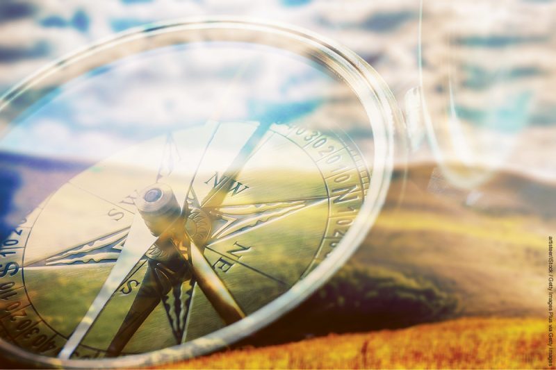 Brass antique compass on background