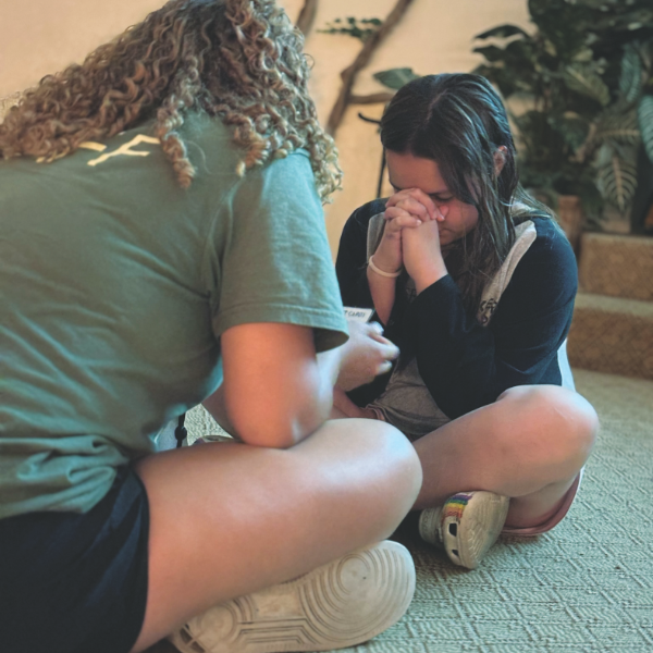 Consejera ora con una niña en Camp Yavapines.