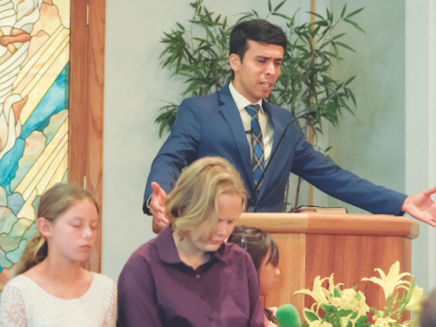 Pastor Daniel Miranda prays at the Orosi church.