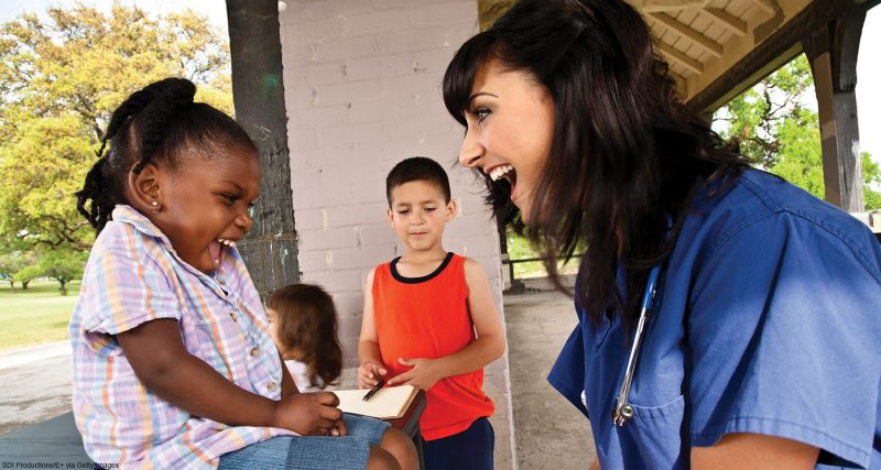Happy Healthcare Professional Giving Health Exam to Children.See more from this series: