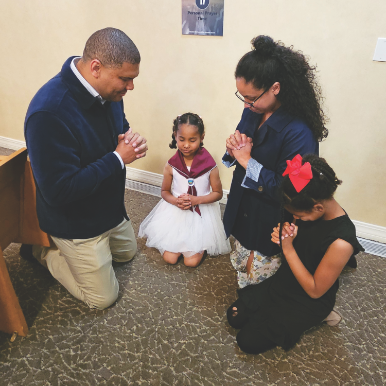 <p>A family pauses for personal prayer at one of the designated stations.</p><p>Una familia hace una pausa para orar personalmente en una de las estaciones designadas.</p>