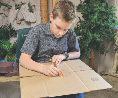 A young participant engages in a creative activity tied to one of the interactive prayer stations.