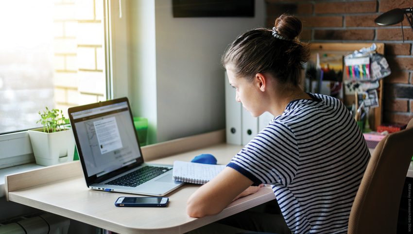 Girl student freelancer working with laptop at home by the window, education and remote work, programmer, online business