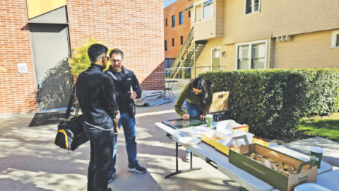 Christian Botello, pastor asociado de la iglesia Eagle Rock, ora con un estudiante de USC durante conocer y saludar de «copa y bendición».