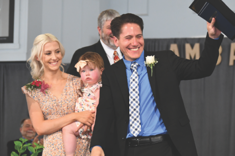 Zack Surovec responds to a cheering crowd alongside his wife, Alicia, and daughter, Everly.