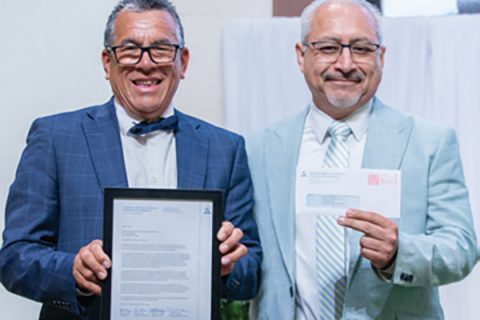 Obdulio Hernandez, first elder (left), and Arturo Cornejo, treasurer (right), hold up a letter from conference leadership and a $2,500 check gifted to the church for ministry.