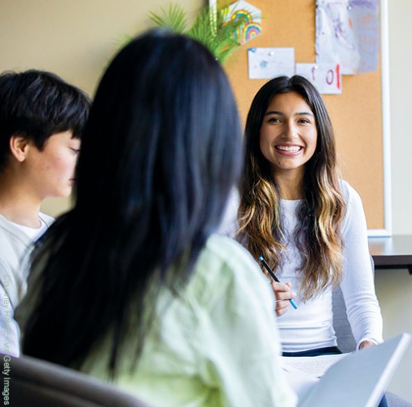 A teen woman sits in a group session with other people in a study group