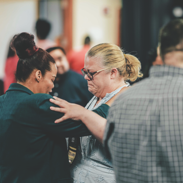 Executive Secretary Chanda Nunes-Henry prays with Pastor Melody Darrow during the closing anointing service.