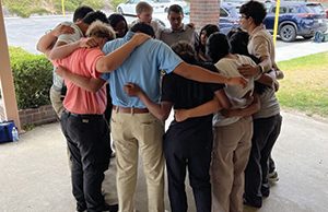 Students gather in a prayer huddle.