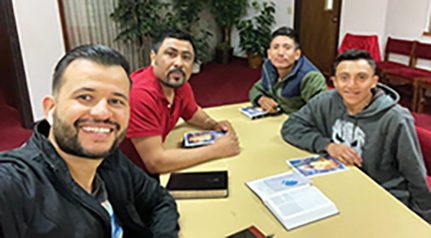 Pastor Vega (far left) coaches one of his members, Roman (second left), as he gives his first Bible study with two friends (both on the right).