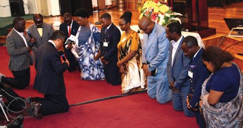 Elder Villamor Meriales leads a prayer of blessing for the leadership team of the Ubumwe church.