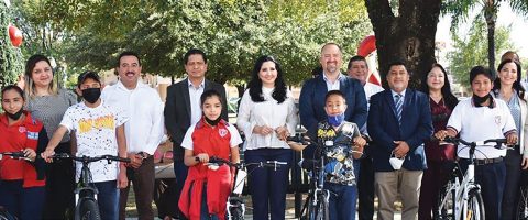 Allende Mayor Patricia Salazar (center) and John Schroer (on her left) attend a community event to distribute bicycles to students.