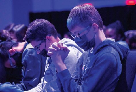 Students bow in prayer at The Experience.