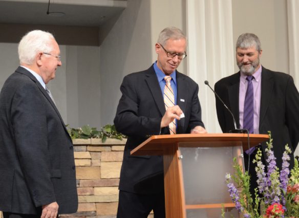 Arizona Conference Treasurer Reggie Leach tears up the “Paid in Full” mortgage for the Bullhead City church. 