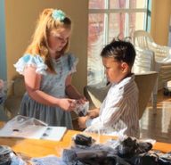 Third-grader Lynn Goulard and second-grader Leki Finau help each other package socks to share with the homeless population in Reno. 