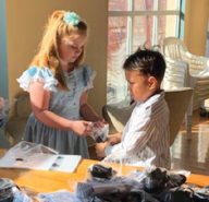Third-grader Lynn Goulard and second-grader Leki Finau help each other package socks to share with the homeless population in Reno.