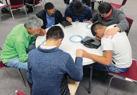 Church members pray with a community member.