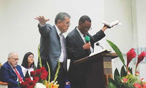 Salazar (left) shares a message encouraging the congregation to renew their commitment to God and the ministry as Franklin Grant (right) translates.