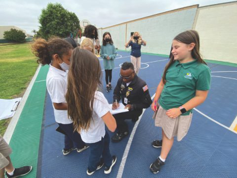 Petgrave signs autographs for students.