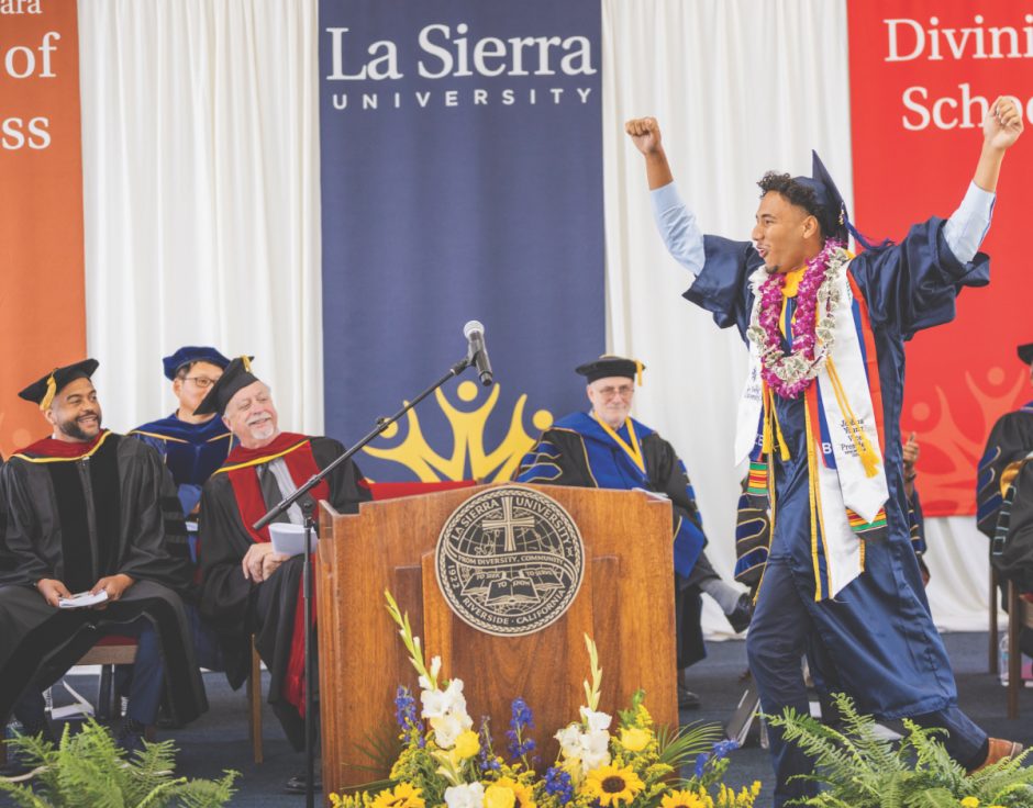 Joshua Young, vice president of the La Sierra University Class of 2022 celebrates as he receives his degree on June 19. Watching are (left to right) Pastor Lawrence Dorsey II; Chang-ho Ji, dean of the School of Education; Bradford Newton, chairman of the board of trustees; and Friedbert Ninow, dean of the H.M.S. Richards Divinity School.