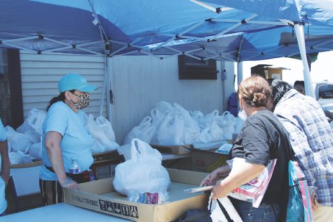 Guests pick up food donated by the church, part of its twice-monthly food bank.