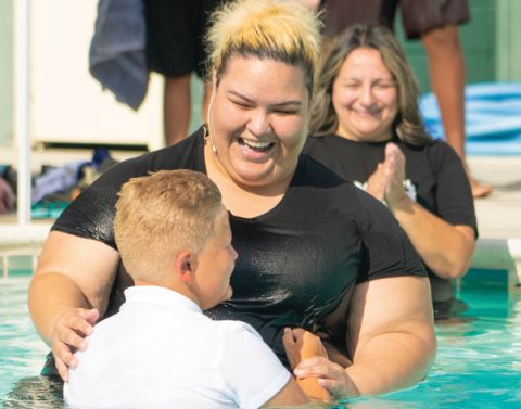 Ibañez smiles as Adams baptizes a camper.