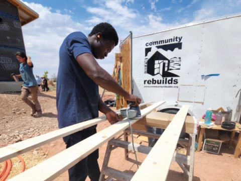 Abraham from the Provo church sands boards as part of the community service project of the Young Adult retreat recently held near Moab, Utah.