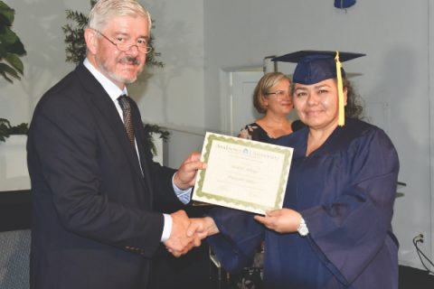 Norton (left) hands a certificate to Maribel Arteaga (right), member of La Voz Sylmar Spanish church. Of the 80 graduates, 15 were women.