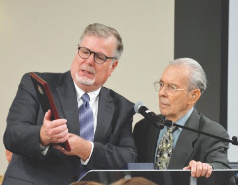 Dale Galusha (left), president of Pacific Press, reads a commemorative plaque given to Paul Damazo, founder and executive director of the Literature Ministry, for bringing the new center from dream to fulfillment. 