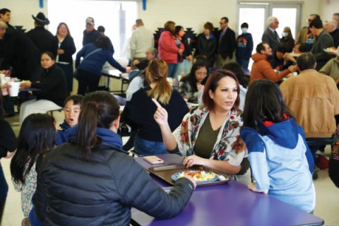 2006 HIS graduate Jovannah Poor Bear-Adams eats in the cafeteria with her children. A little over 15 years ago, she ate in this same cafeteria as a student for the first time, relishing her first day receiving three healthy meals.