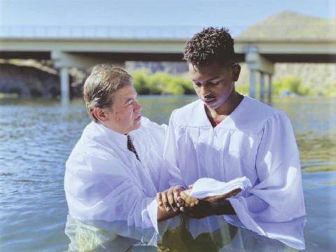 Elder Ed Anderson baptizes a young man in the Salt River.
