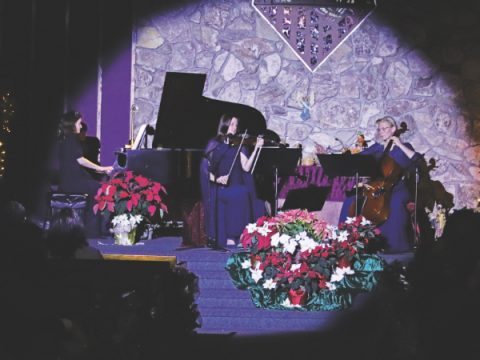 (From left to right) Hannah, piano; Lena, violin; and Olga, cello, perform a variety of Christmas songs at the December concert.