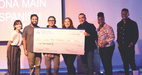 (Starting second from left to right) Gabriel Mendoza, Joel Mendoza, Cindy Rivas, and Diego Najera accept the Audience Choice Award from SECC staff on behalf of Corona Main Street Spanish church. / (De izquierda a derecha) Gabriel Mendoza, Joel Mendoza, Cindy Rivas y Diego Nájera aceptan el Premio del Público del personal de SECC en nombre de la iglesia hispana de Corona Main Street.