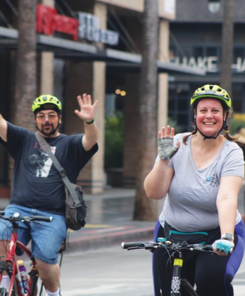 Alburn (left) and Kelsy (right) bike through the open Hollywood boulevard.
