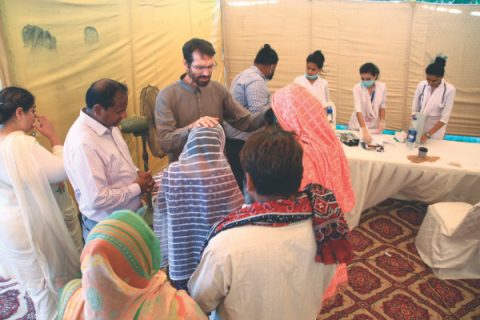Rodney Bowes prays for people who attended the health camp.