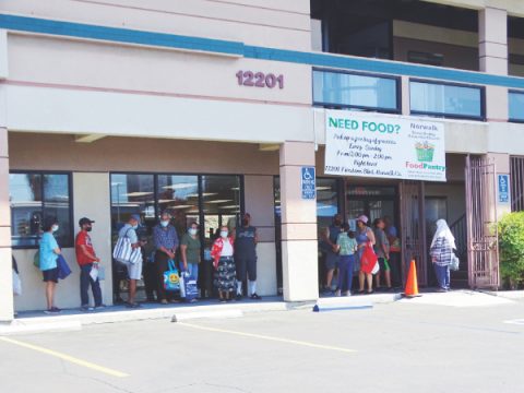 Miembros de la comunidad hacen fila para la despensa de alimentos.