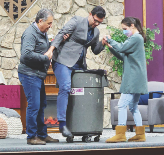 During his message, entitled “Lord, I Will Go! Free Me,” Garcia (center) demonstrates the power of temptation by at first resisting, then climbing into a trash can—and the difficulty that may come with getting stuck.
