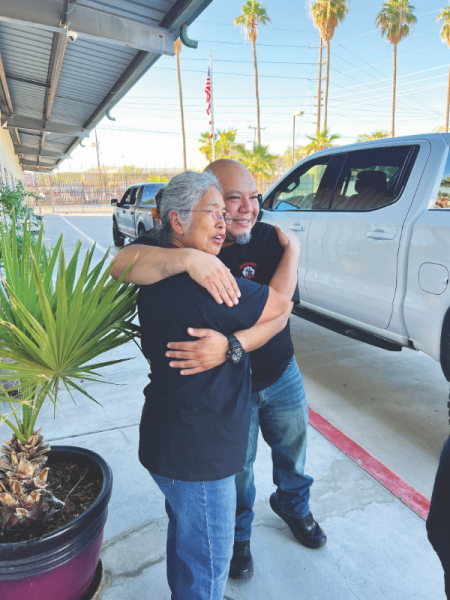 Johnston and former student Ernie Valadez embrace.<br /> Johnston y el exalumno Ernie Valadez se abrazan.