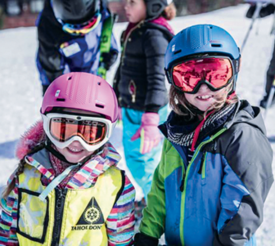 Los felices esquiadores y snowboarders adquieren habilidad y confianza en una escuela de esquí bien administrada en la zona de esquí de Tahoe-Donner. 